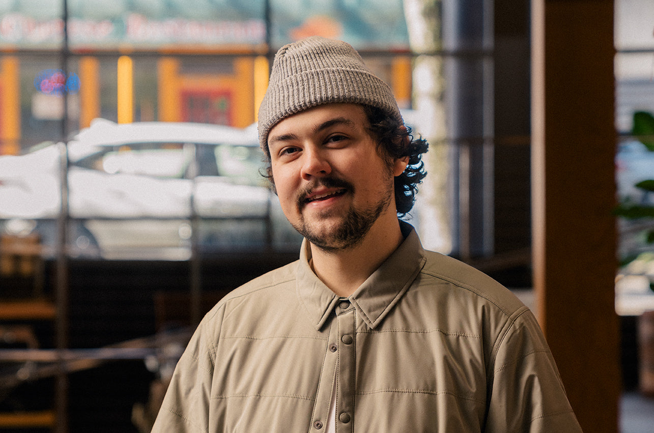 A retail associate in Portland, Oregon wearing a snow peak shirt and hat
